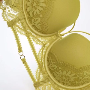 Détail du soutien-gorge en dentelle vert citron avec motifs floraux et anneaux dorés