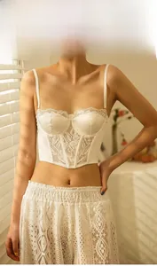 Close-up of white satin and lace corset bra top with intricate floral lace texture