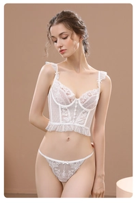 Détail d'un ensemble de lingerie en dentelle blanche avec ourlet volanté et boutons