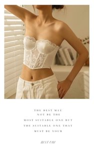 Detail of white lace and satin corset top featuring floral mesh and structured boning