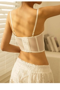 Detail of white lace bustier back with adjustable straps and multi-row hook eye closure