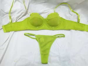 Detail view of lime green lace lingerie set with geometric patterns and thong