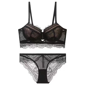 Flat lay of elegant black floral lace lingerie set with mesh details on white background