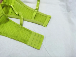 Detail view of neon green lace bra with three-row hook closure and adjustable straps