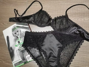 Détails de lingerie en satin noir avec maille léopard et dentelle sur fond de bois