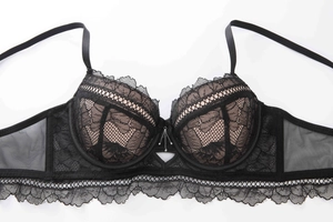 Detail of 3/4 cup black lace bra featuring delicate floral embroidery and sheer mesh layers
