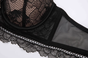 Close-up detail of black lace floral pattern and eyelash trim on a structured bra cup