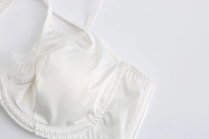 Détail d'un soutien-gorge en satin blanc avec dentelle cils et armatures de maintien