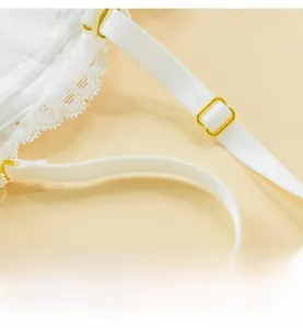 Detail of white lace camisole with adjustable shoulder straps and gold metal buckles