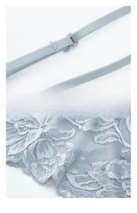 Detail of adjustable thin shoulder straps and delicate light blue floral lace hem