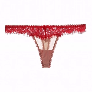 Vue détaillée de la bordure en dentelle de cils rouge et du nœud sur le string taille basse