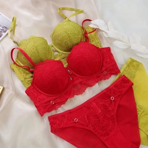 Flat lay of luxury red and lime lace lingerie sets with intricate floral embroidery