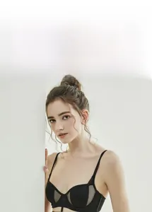 Close-up of black lace bra with sheer mesh embroidery and delicate shoulder straps