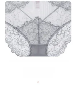 Macro detail of sheer floral lace and eyelash trim on light grey low-rise panties