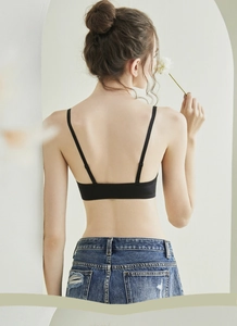 Detail view of black low-back bra with thin straps and seamless skin-friendly material