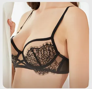 Détail du soutien-gorge en dentelle noire avec anneaux dorés et maille transparente chic