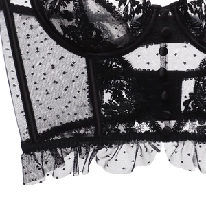 Detail of black lace corset with floral embroidery and mesh ruffles on white background