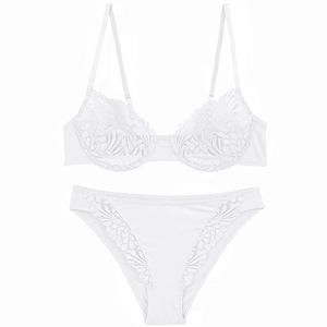 Detailed view of the intricate white floral lace and scalloped edges on the bra and panty