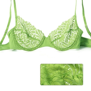 Close-up view showing the intricate floral lace texture and stitching of the green bra