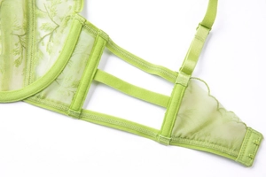 Detailed macro view of lime green lace embroidery and sheer mesh on a French style bra