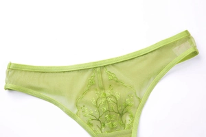 Detail showing sheer grass green lace mesh underwear with delicate leaf embroidery