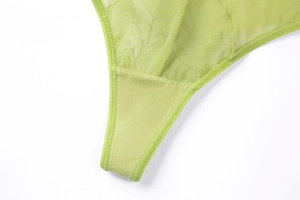 Close-up of yellow-green floral embroidery and stitching on breathable mesh lace thong