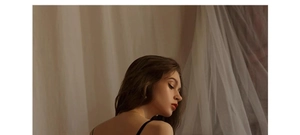 Close-up of black satin lingerie with thin straps showing back detail and lace textures