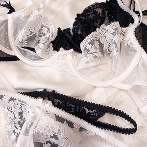 Detailed close-up of floral embroidery lace and mesh fabric on elegant lingerie sets