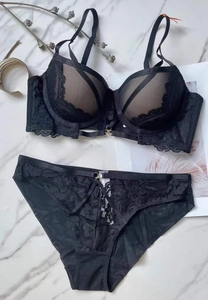 Set lingerie in pizzo nero con inserti in mesh e dettagli di gioielli dorati