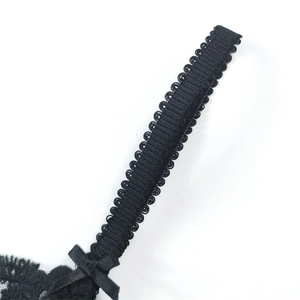 Close-up of black lace bra strap with scalloped edge and delicate bow detail