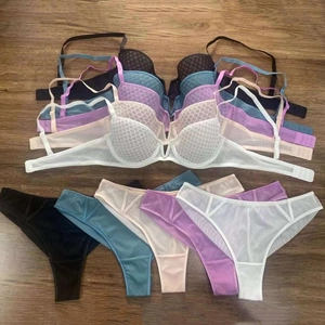 Flat lay of lace lingerie sets with honeycomb mesh design in multiple colors on wood