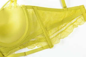 Detailed close-up of lime green floral lace bra with golden metallic strap adjusters