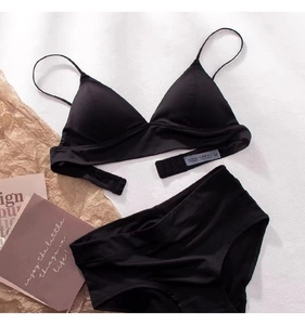Flat lay of black triangle bikini set with thin straps on a minimalist background
