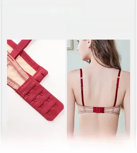 Detail of red lace bra featuring four-row hook-and-eye closure and adjustable straps
