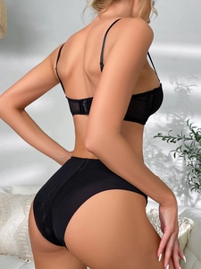 Détail d'un ensemble de lingerie en maille noire avec textures transparentes sur un mannequin