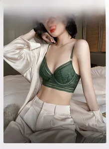 Detailed view of dark green floral lace bra with elegant silk shirt overlay
