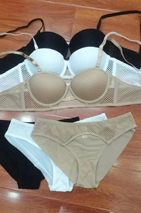 Détail de trois ensembles de lingerie en résille noir, blanc et kaki avec motifs ajourés