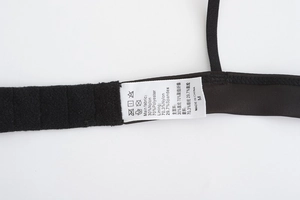 Detail shot of black lace bra care label showing fabric composition and M size info