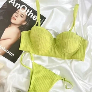 Detailed view of neon green lingerie set with knit texture on silk background