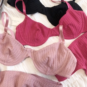 Detailed macro view of waffle-textured lace lingerie set in black and pink shades
