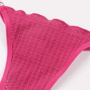 Détail macro du tissu gaufré rose fuchsia avec bords festonnés et anneau métallique