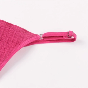 Gros plan du tissu gaufré rose avec boucles de réglage en métal argenté sur la sangle