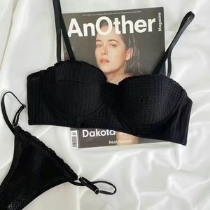 Flat lay of black lace lingerie set with wired bra and thong on white silk fabric