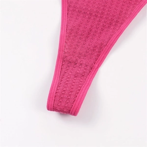 Détail du tissu en maille gaufrée rouge rose et couture renforcée sur ce string pour femme