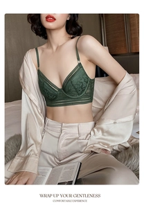 Detail of dark green eyelash lace bra with elegant champagne silk robe at a cozy bedroom