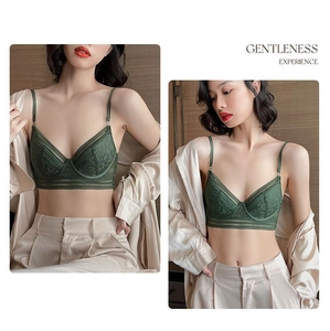 Detail of elegant dark green lace bra with wireless triangular cups and mesh details