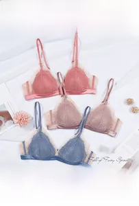 Détails à plat de soutiens-gorge en dentelle corail, violet et bleu sur tissu blanc