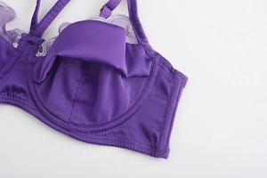 Detail of purple satin and lace bra showing refined stitching and adjustable gold buckles