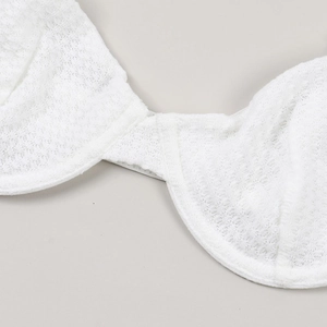 Macro view of white lace bra texture with breathable mesh fabric and underwire detail