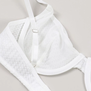 Detail of white lace and mesh bra featuring fine texture and adjustable silver buckle